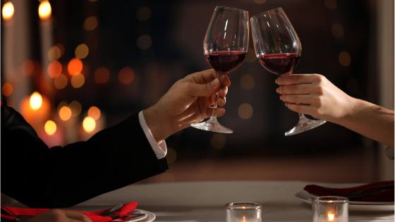 a couple toasting wine at a dinner table